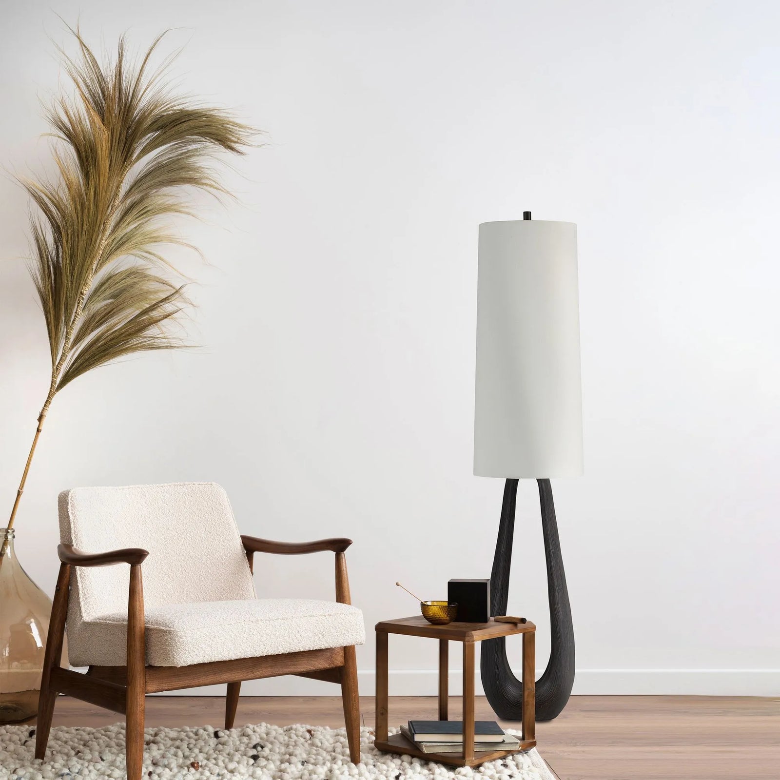 A living room with a couch and  Becky Floor Lamp with a white shade and a brown twisted base.