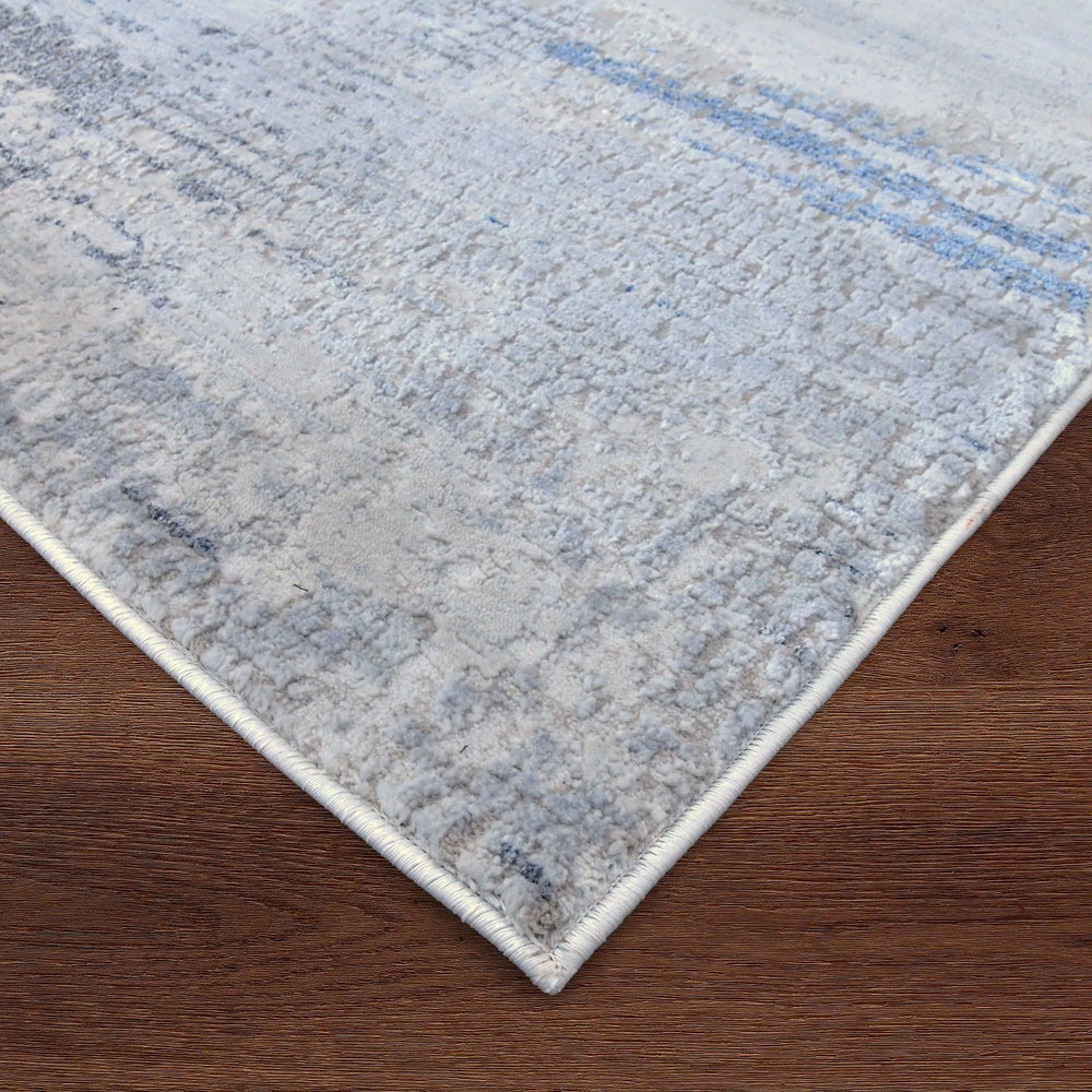 Close-up of a textured rug with a gradient pattern on a wooden floor.