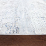 Textured white rug with blue specks on a wooden floor