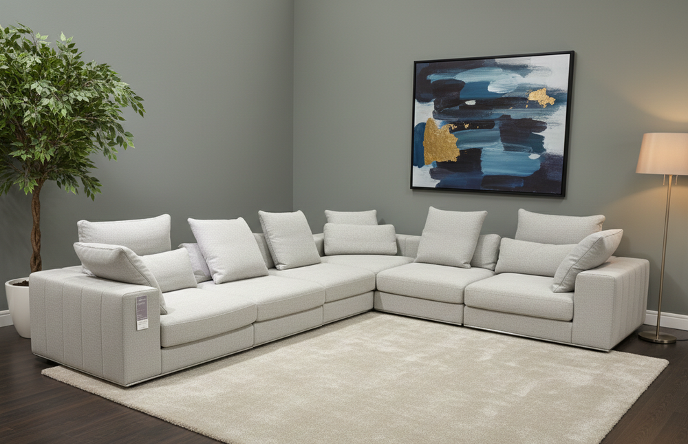 Gray sectional sofa in a living room with a abstract painting on the wall.