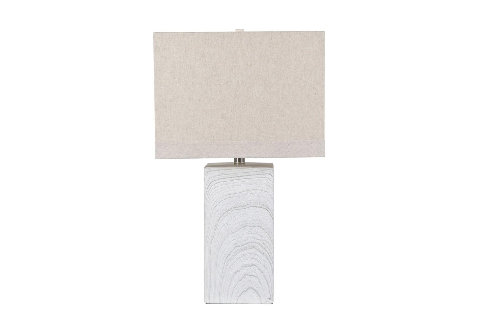 A transitional style table lamp with a beige shade and a white ceramic base with a channelled pattern.