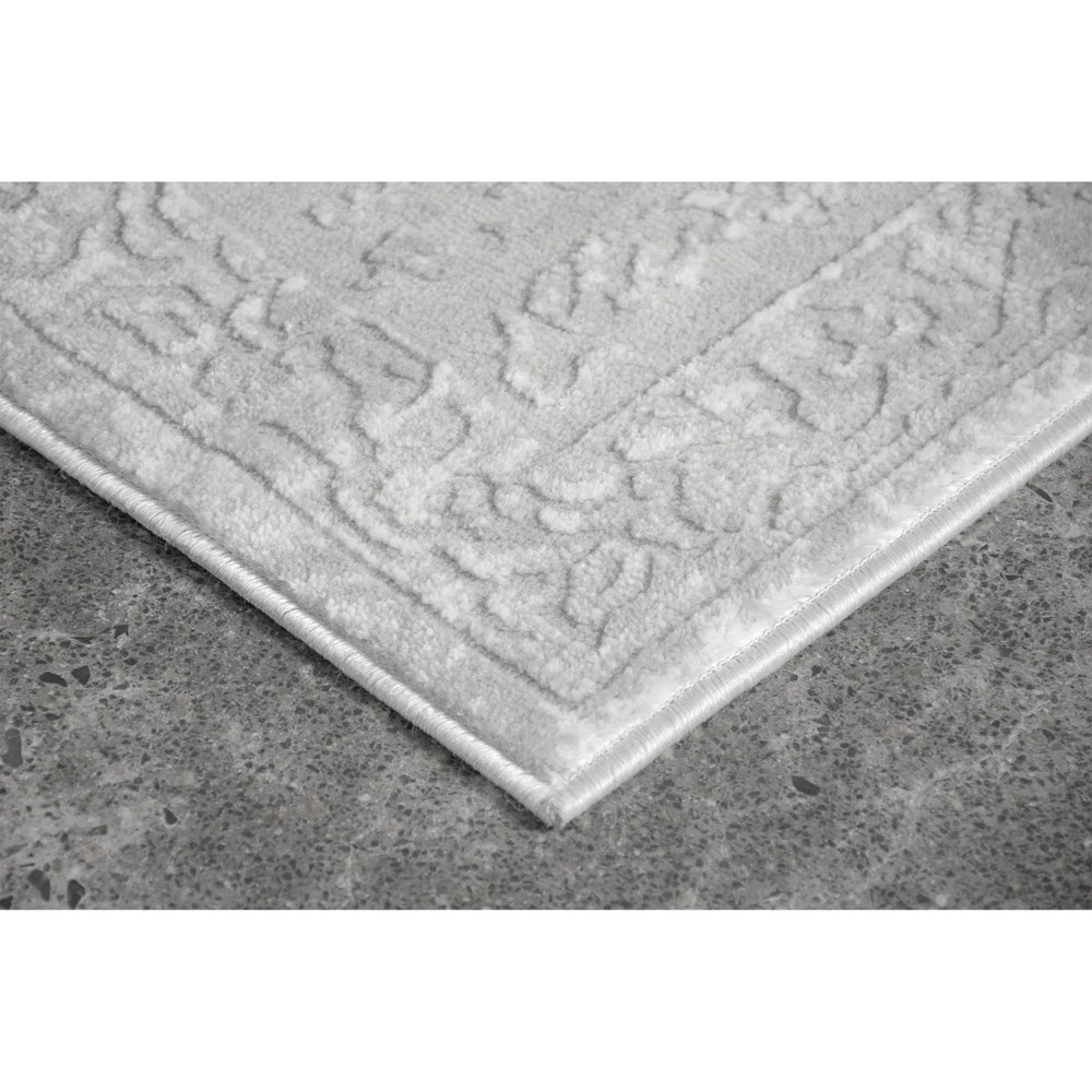 Textured gray rug on a concrete floor