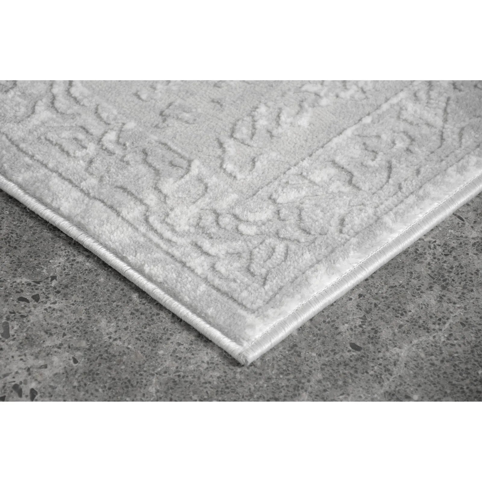 Textured gray rug on a concrete floor
