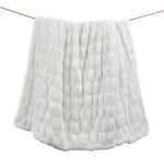 White textured blanket draped over a wooden stick on a white background