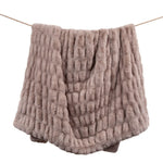 Textured pink blanket draped over a white background