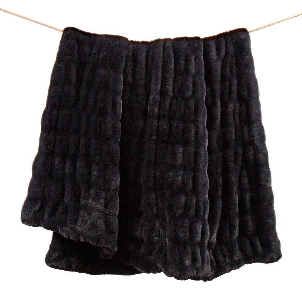 Black textured blanket draped over a white background