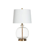Table lamp with white shade and clear glass base on a white background