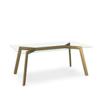 A clear glass top dining table with a brass accent base.