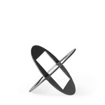 A round, black metal decorative object with a geometric design.