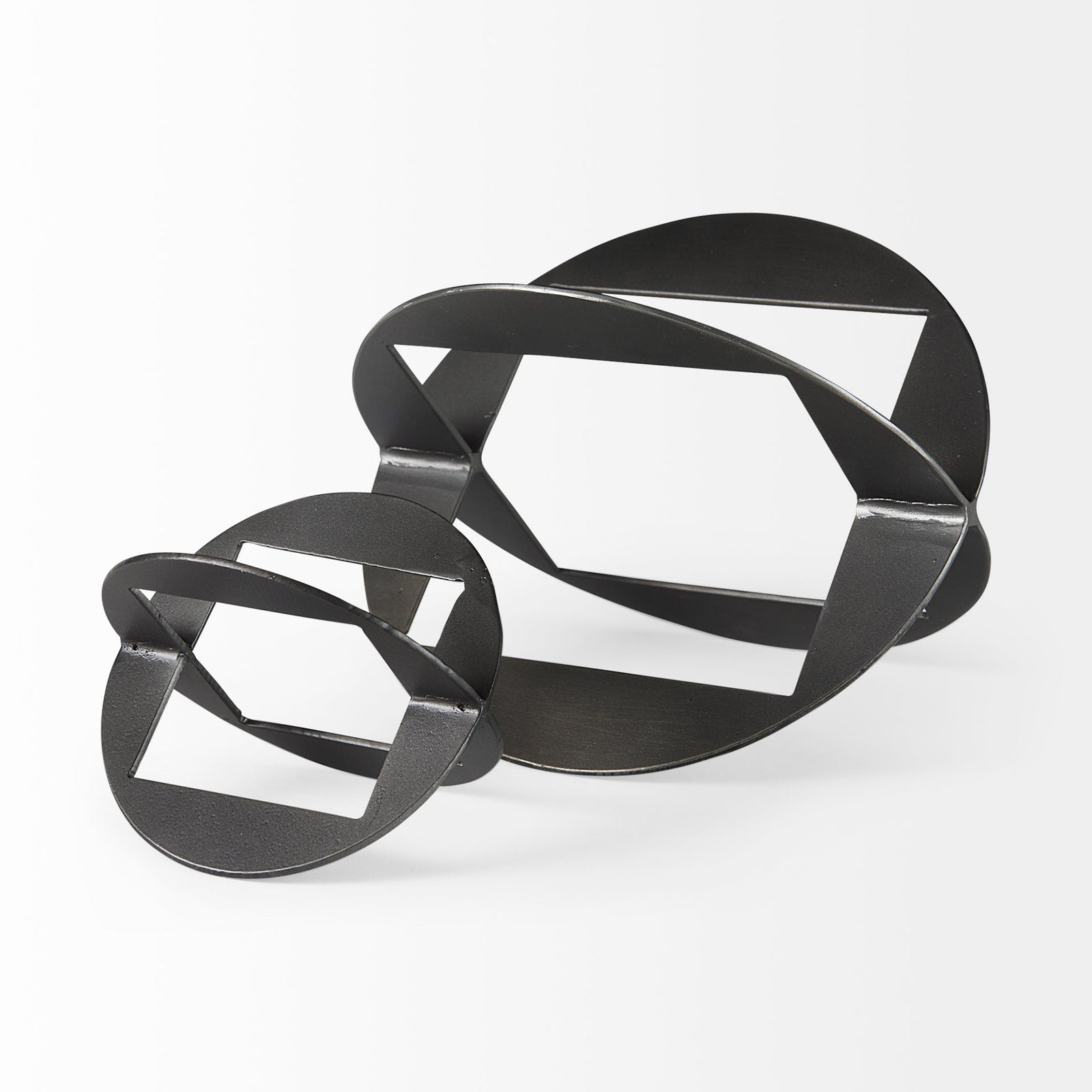 A round, black metal decorative object with a geometric design.