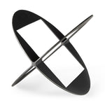 A round, black metal decorative object with a geometric design.
