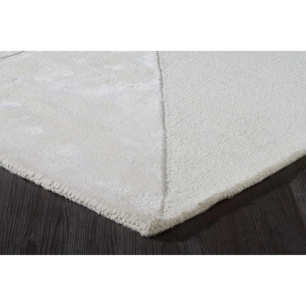 Close-up of a textured white rug corner on a dark surface