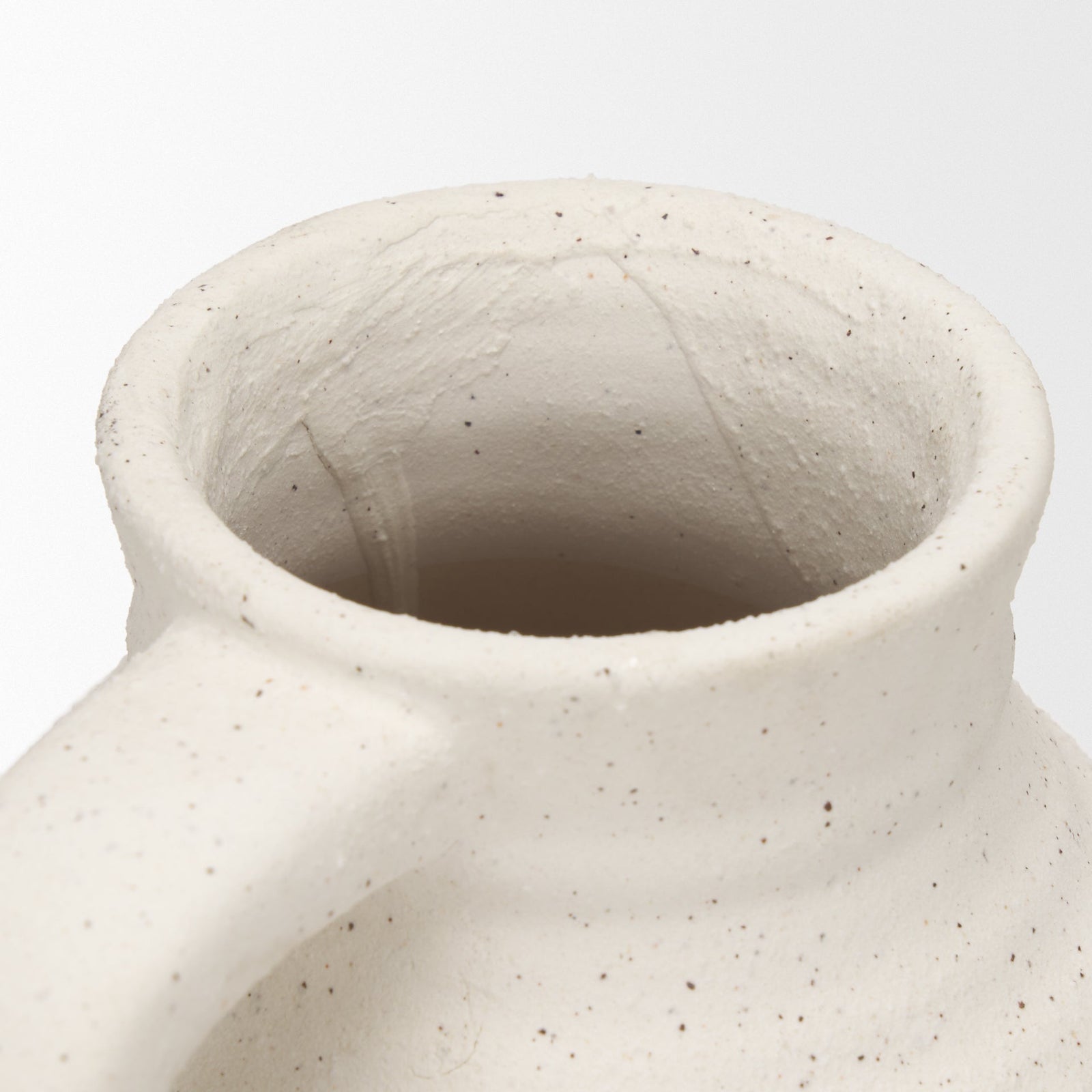 Close-up of a textured ceramic vase on a white background