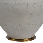 Close-up of a textured ceramic vase with a brass base on a white background