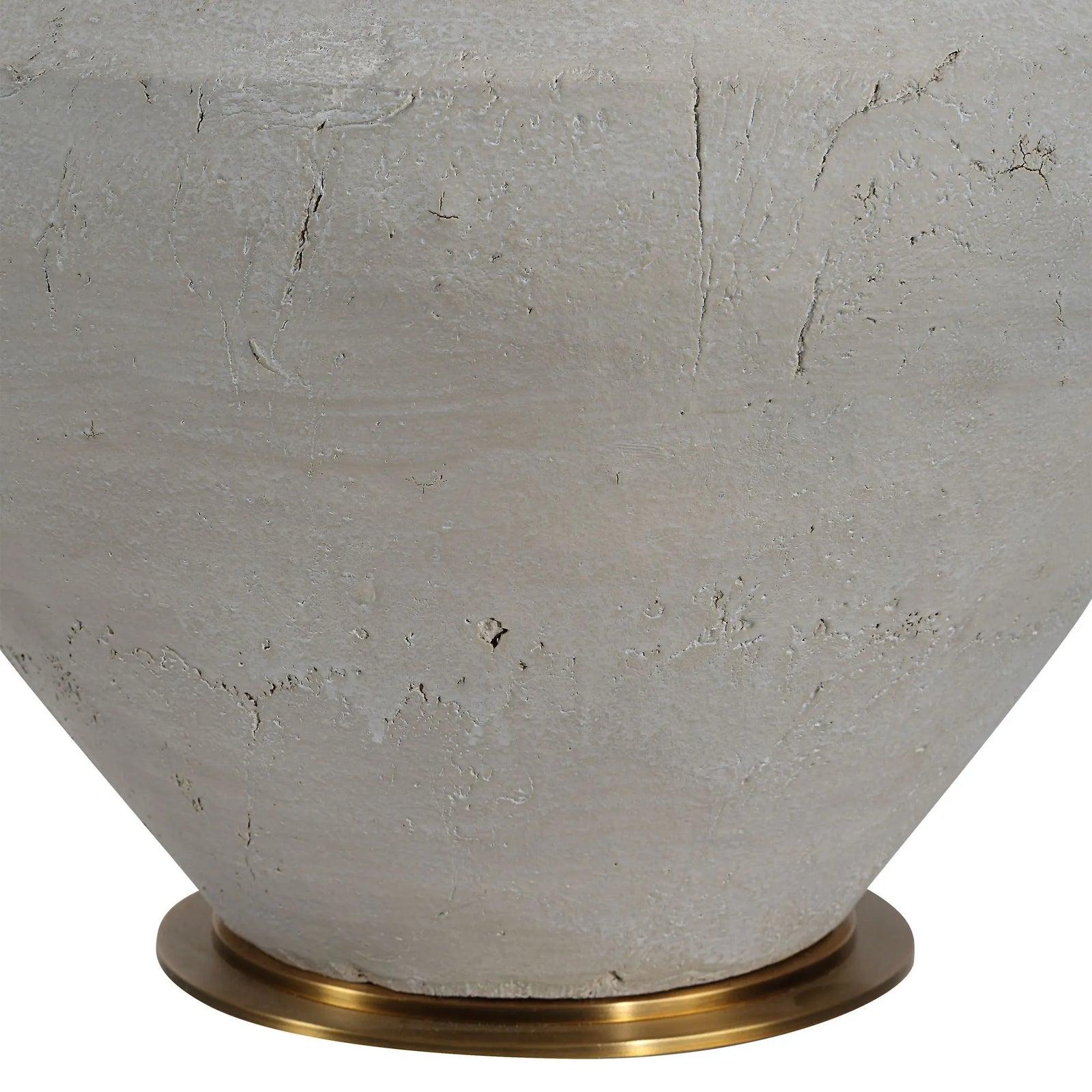 Close-up of a textured ceramic vase with a brass base on a white background