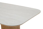 Close-up of a modern dining table with a light gray surface and wooden base.