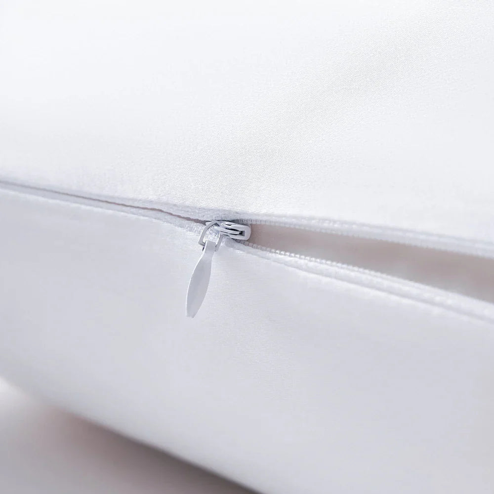 Close-up of a white pillow with a zipper on a light gray background
