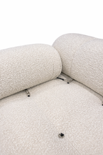Close-up of a textured beige sofa with visible screws on a white background