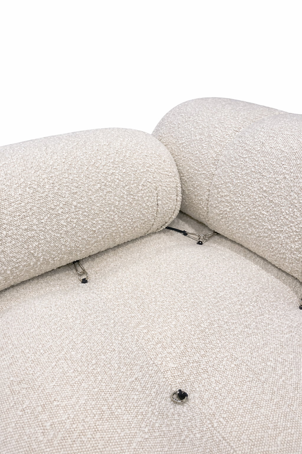 Close-up of a textured beige sofa with visible screws on a white background
