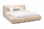Beige bed with rounded edges and white bedding on a white background