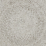 A round, beige area rug with a swirling geometric design