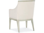 A beige upholstered dining chair with armrests and wooden legs, viewed from a front angle.