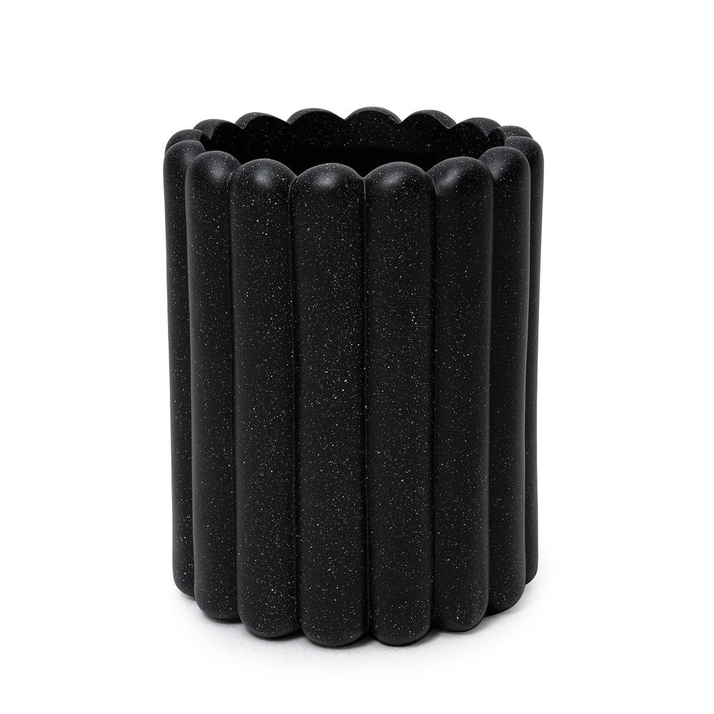 A black cylindrical fiberglass planter with a ribbed design.