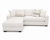 A light cream or off-white upholstered sectional sofa with a left-facing chaise lounge, styled with four throw pillows including two striped accent pillows, set against a plain white background.