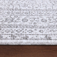 Close-up of a textured rug with a pattern on a wooden floor.