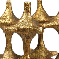 Gold metallic sculpture with intricate design on a white background