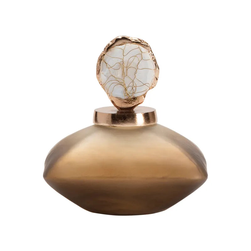 A gold-colored bottle accent with a textured surface and a rounded shape designed to sit on top of a bottle.