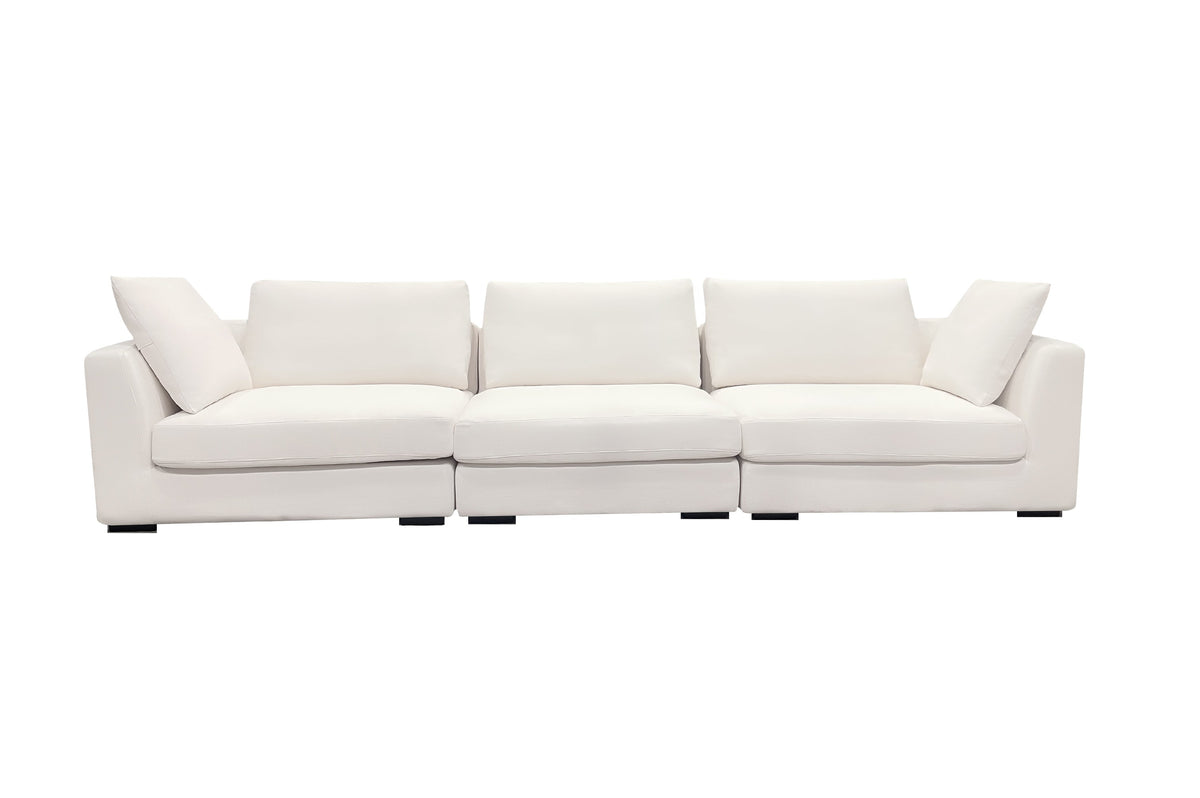 A beige luxury sectional sofa with multiple cushions, featuring a subtle curve design, set against a white background.