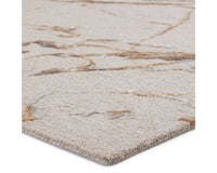 A dark dove and gold area rug with a textured surface featuring cracks and seams, resembling a natural stone or marble appearance.