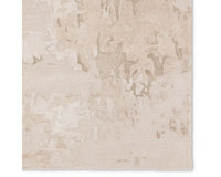 A beige and gray area rug with a textured design, hand tufted construction, and a viscose and wool blend.