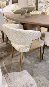 Dining room with wooden table and textured chairs on a gray rug