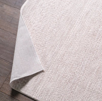 Close-up of a textured white rug on a wooden floor