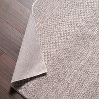 Gray textured rug on a wooden floor