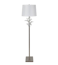 Floor lamp with decorative base and white shade on a white background