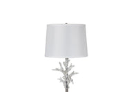 Close-up floor lamp with decorative base and white shade on a white background
