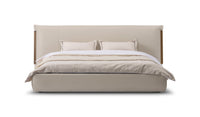 Beige upholstered bed with white bedding on a white background