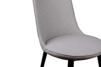 A gray upholstered dining chair with slim black matte finish steel legs.