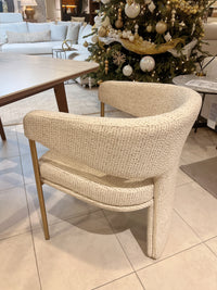 Beige wicker chair in a room with a decorated Christmas tree and furniture.