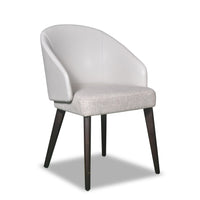 A white upholstered dining chair with a full back and seat, featuring dark brown wooden legs.