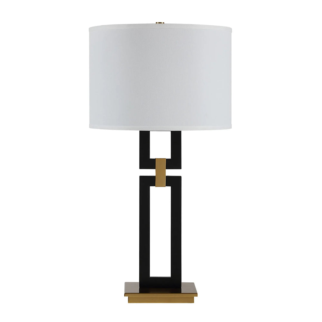 Table lamp with a white shade, black and gold base on a white background