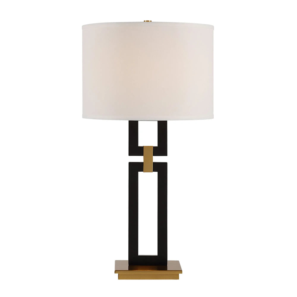 Table lamp with a black and gold base and white shade on a white background
