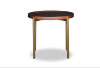 Round wooden table with black top and brass legs on a white background