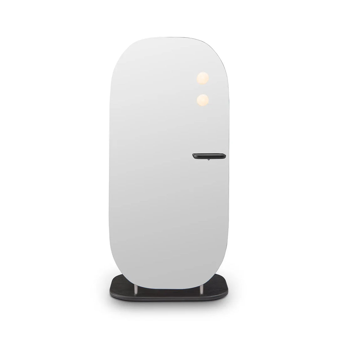 White cylindrical device on a black stand against a white background