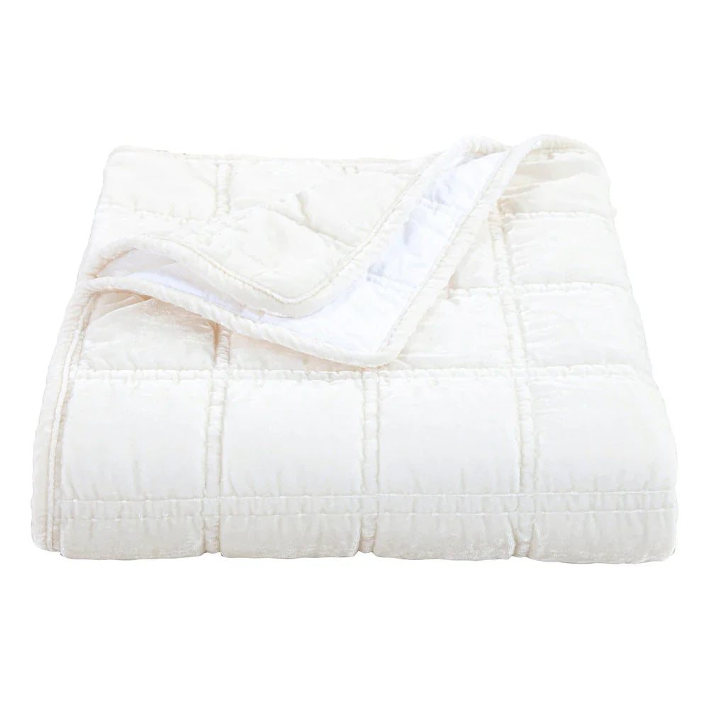 White quilted comforter on a white background