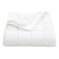 White quilted comforter on a white background