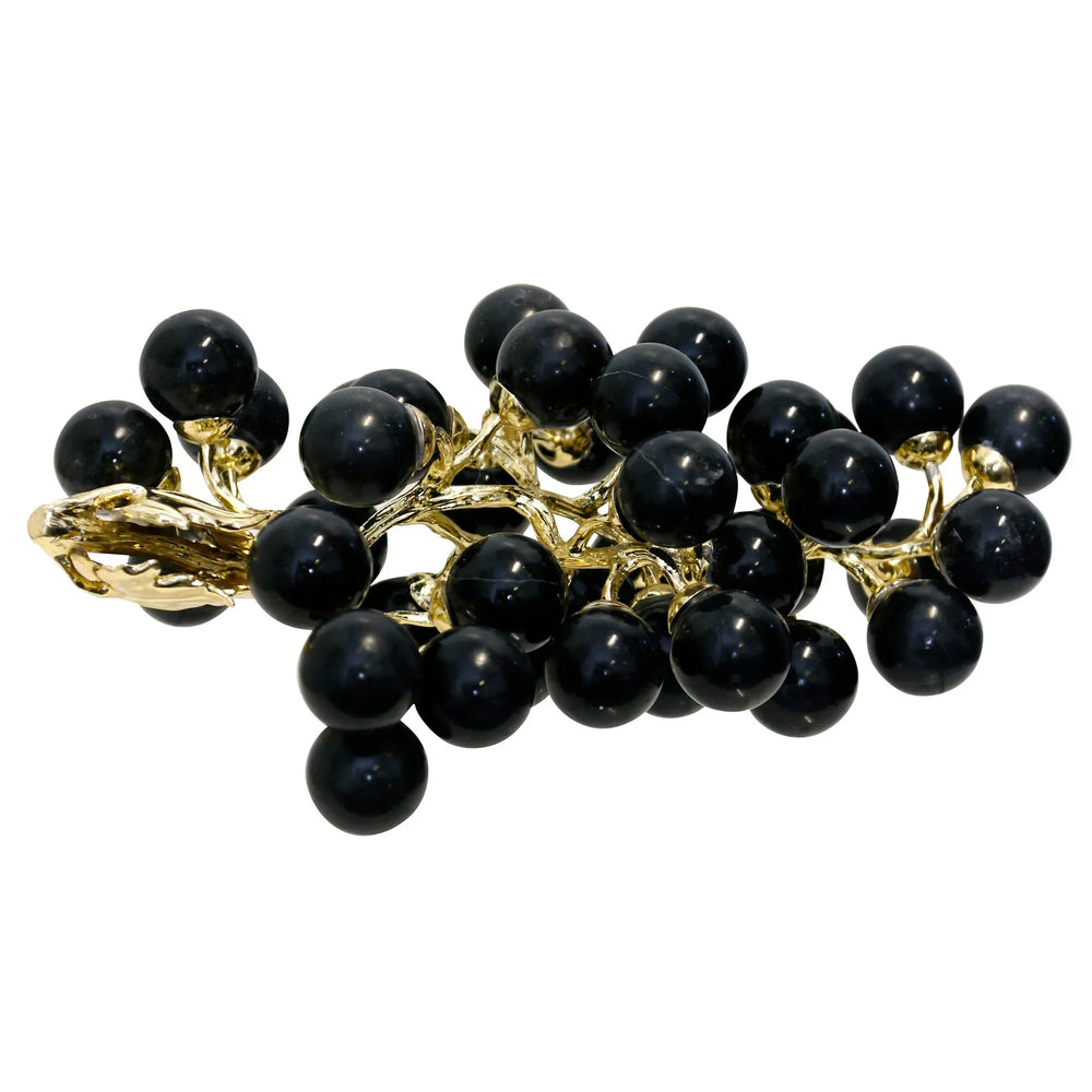 Black grape cluster brooch with gold accents on a white background